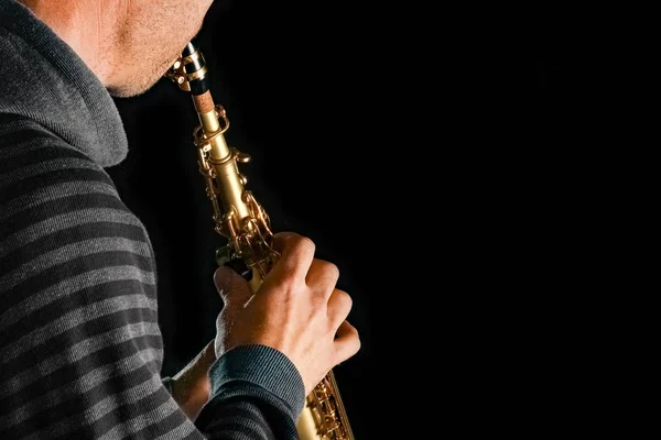 Soprán saxofon v rukou člověka na černém pozadí — Stock fotografie