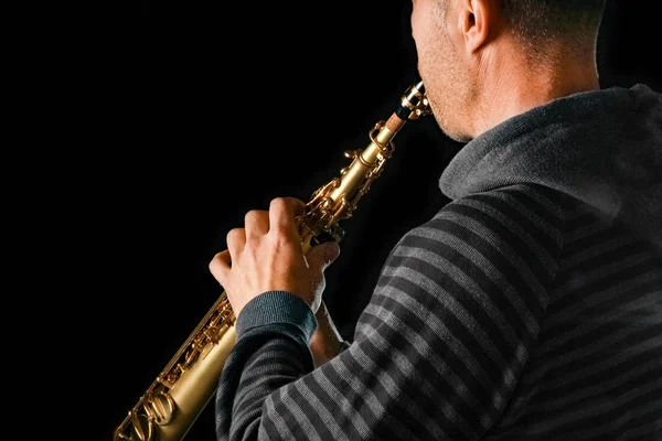 Saxophone soprano dans les mains d'un mec sur fond noir — Photo