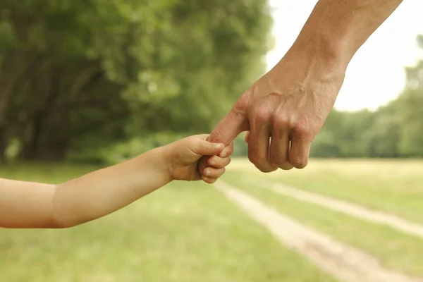 Pai segura a mão de uma criança pequena — Fotografia de Stock