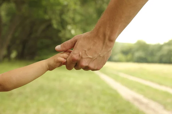 Eltern halten die Hand eines kleinen Kindes — Stockfoto