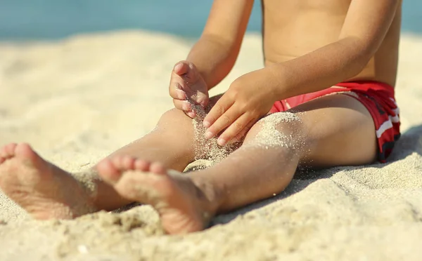 Pernas de uma criança na areia na praia — Fotografia de Stock