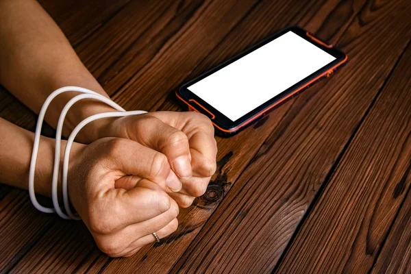 phone with hands addiction on a wooden background