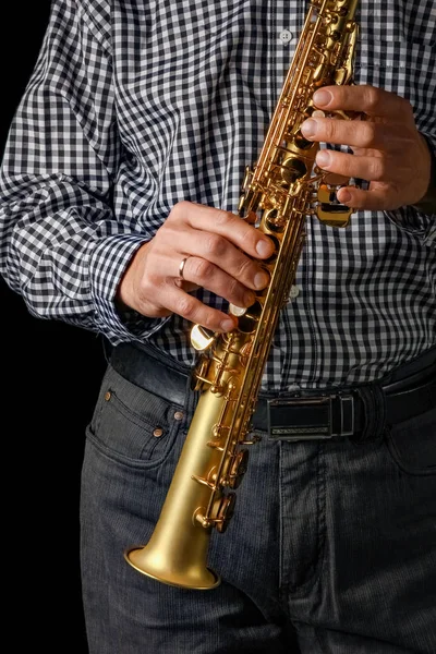 Saxophone soprano dans les mains sur fond noir — Photo