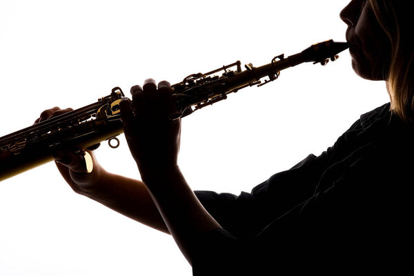 саксофон на белом фоне в руках музыканта силуэта
