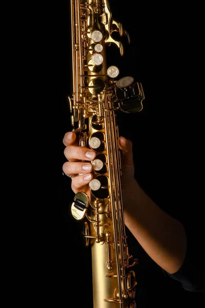 Саксофон сопрано в руках на черном фоне — стоковое фото