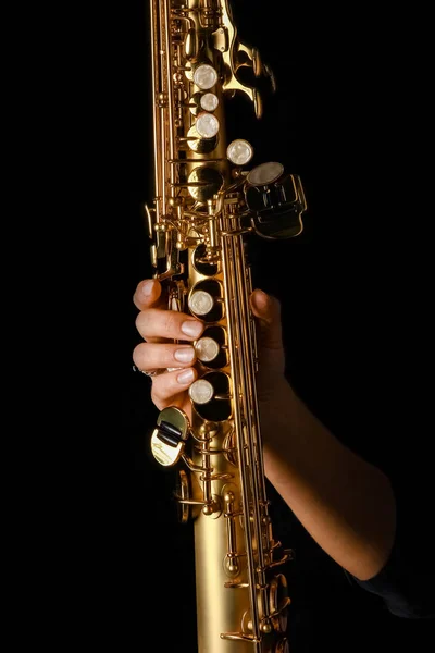 Soprano saxofone em mãos sobre um fundo preto — Fotografia de Stock