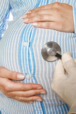 Mutlu hamile kız beyaz arka planda yatıyor.