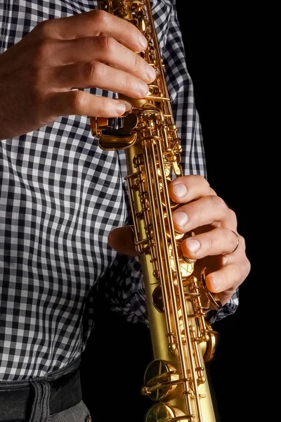 Soprano saxophone in hands on a black background — Stock Photo, Image