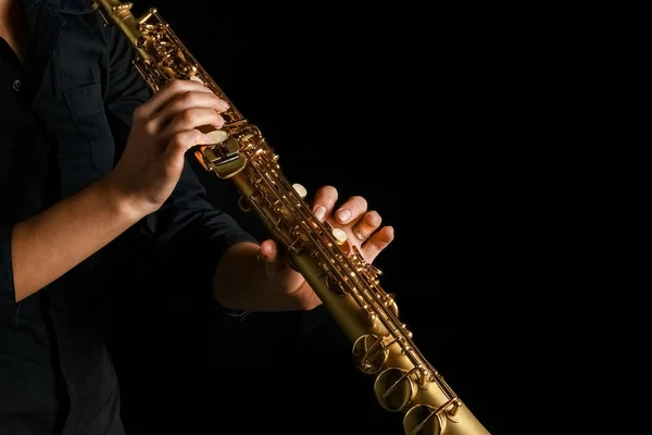 Soprano saxofone em mãos sobre um fundo preto — Fotografia de Stock