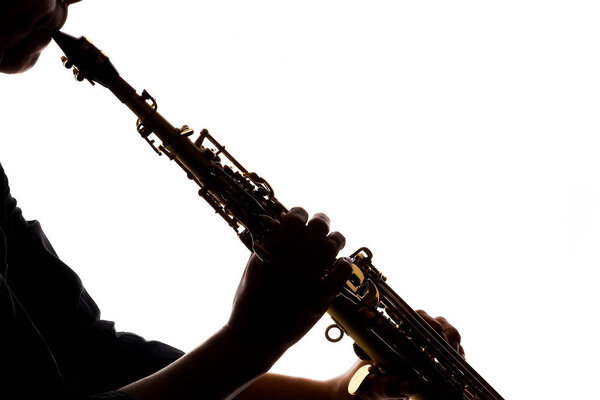 саксофон на белом фоне в руках музыканта силуэта
