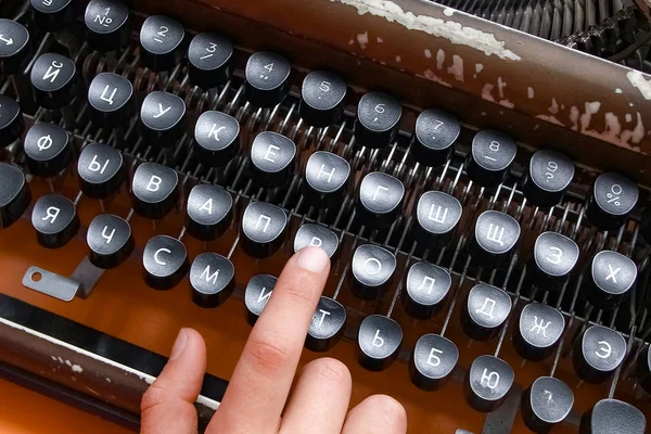 Uma velha máquina de escrever com as mãos antigas — Fotografia de Stock