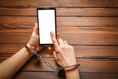 Telefon ahşap bir arka planda el bağımlılığı