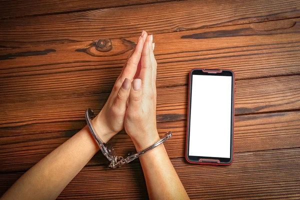 Телефон з залежністю рук на дерев'яному фоні — стокове фото