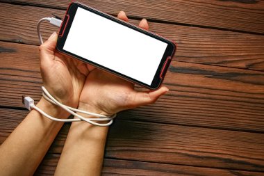 Telefon ahşap bir arka planda el bağımlılığı