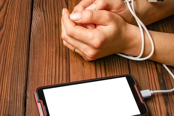 phone with hands addiction on a wooden background