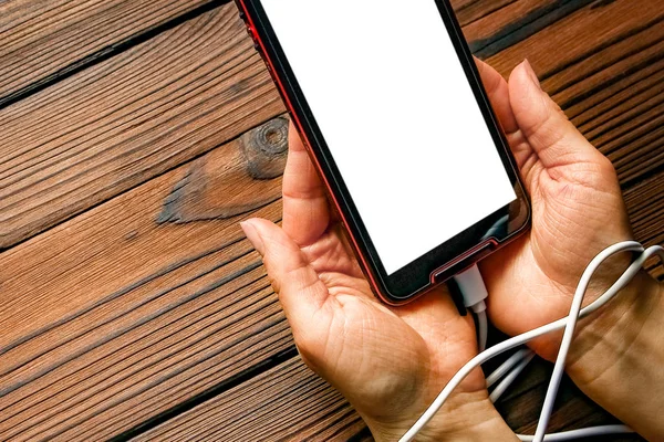 Teléfono con manos adicción sobre un fondo de madera —  Fotos de Stock