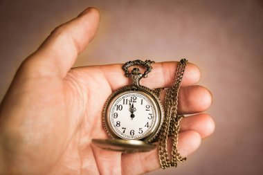 Bir adamın elinde bir cep saati.