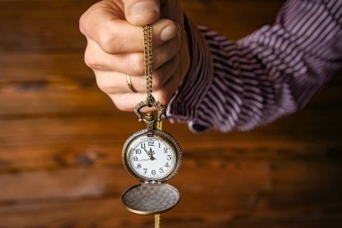 Bir adamın elinde bir cep saati.