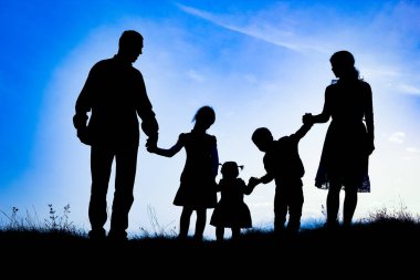 Deniz kenarında mutlu bir aile, doğanın siluetinde.