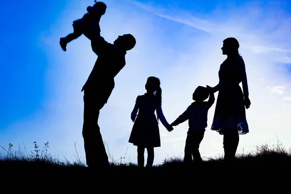 Gelukkig familie aan zee op natuur silhouet achtergrond — Stockfoto