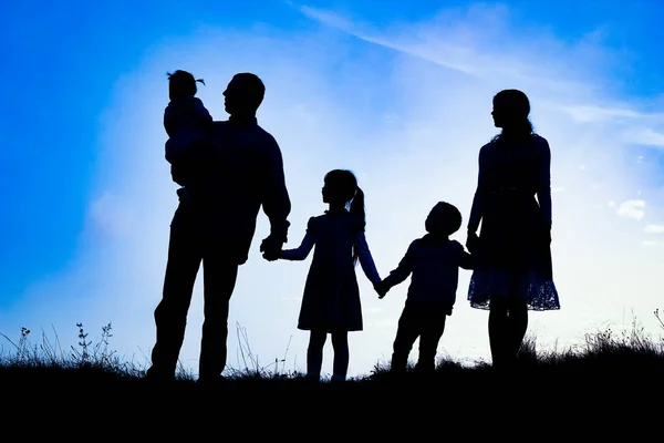 Deniz kenarında mutlu bir aile, doğanın siluetinde. — Stok fotoğraf