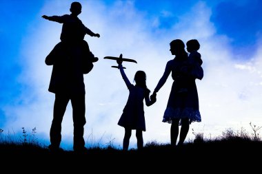 Deniz kenarında mutlu bir aile, doğanın siluetinde.