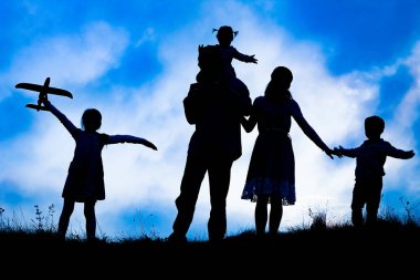 Deniz kenarında mutlu bir aile, doğanın siluetinde.