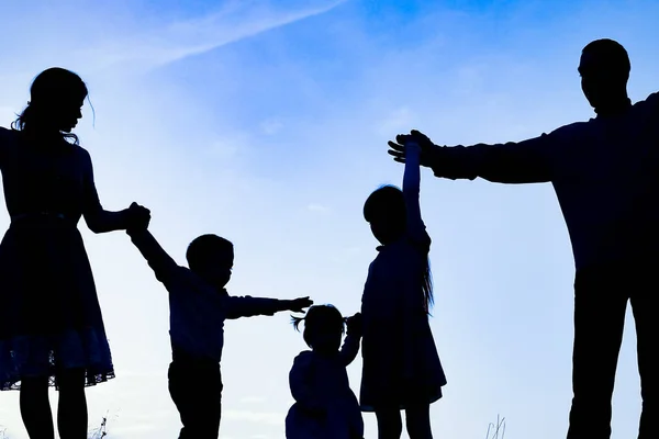 Happy family by the sea on nature silhouette background — Stock Photo, Image