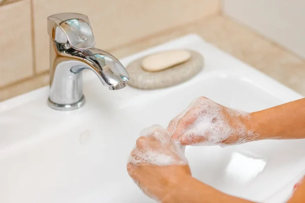 Ein Händewaschen mit Seife unter dem Wasserhahn mit Wasser — Stockfoto