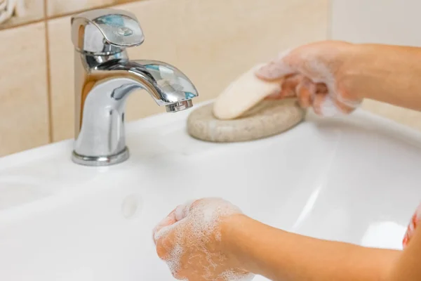 Ein Händewaschen mit Seife unter dem Wasserhahn mit Wasser — Stockfoto