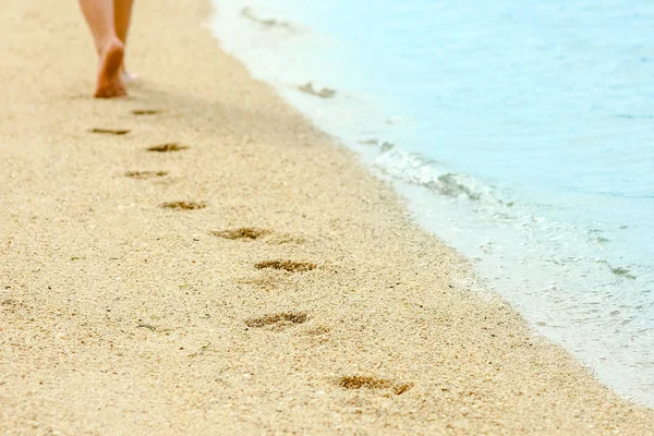 Mooie voetafdrukken in het zand door de zee achtergrond — Stockfoto