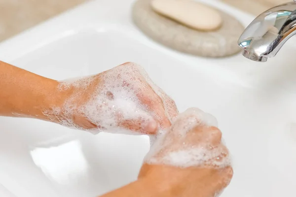 A Lavarse las manos con jabón debajo del grifo con agua — Foto de Stock