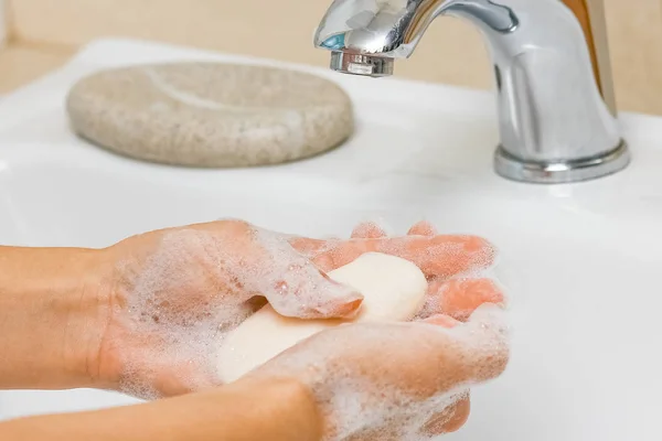 Ein Händewaschen mit Seife unter dem Wasserhahn mit Wasser — Stockfoto