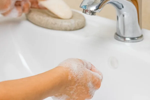 Ein Händewaschen mit Seife unter dem Wasserhahn mit Wasser — Stockfoto