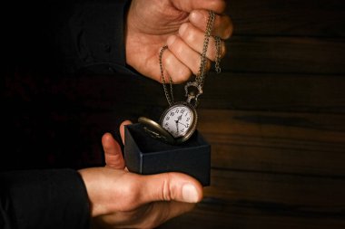 Bir adamın elinde bir cep saati.