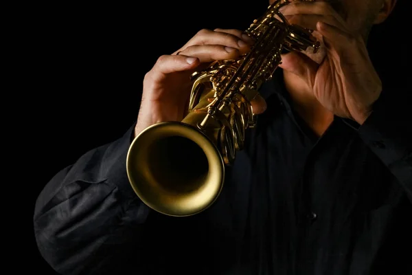 Soprano saxofone em mãos sobre um fundo preto — Fotografia de Stock