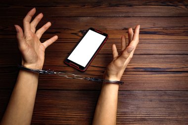 Telefon ahşap bir arka planda el bağımlılığı