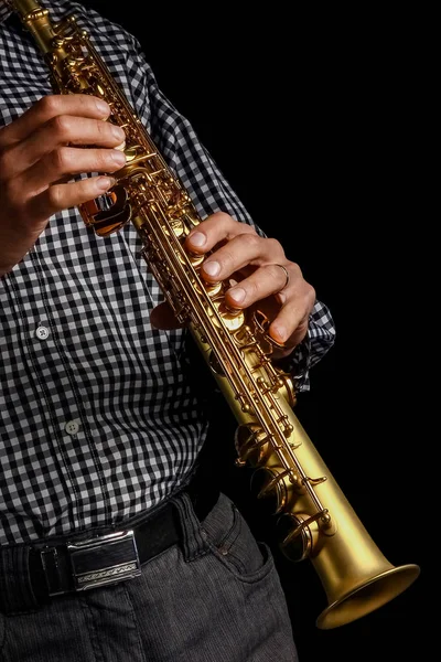 Saxofón soprano en manos sobre fondo negro — Foto de Stock