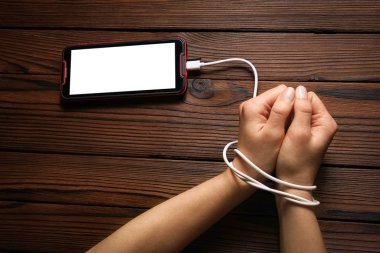 Telefon ahşap bir arka planda el bağımlılığı