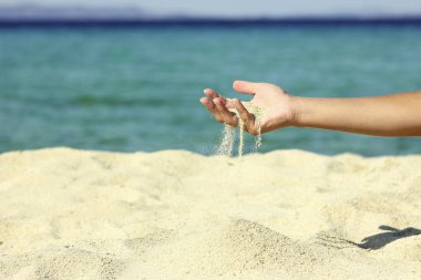 Kadın eli kum döker. 