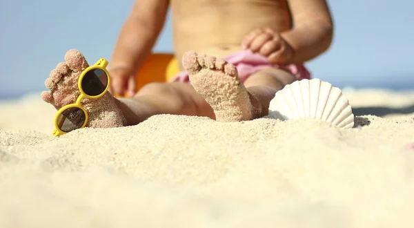 Piernas de un niño en la arena en la playa — Foto de Stock