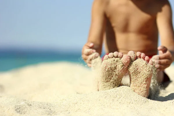 Gambe di un bambino sulla sabbia sulla spiaggia — Foto Stock