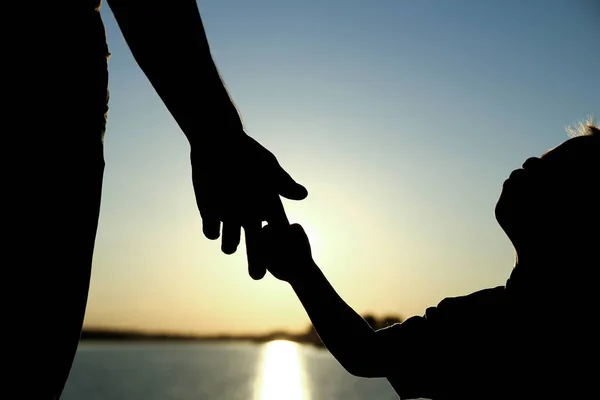 Silueta el padre sostiene la mano de un niño —  Fotos de Stock