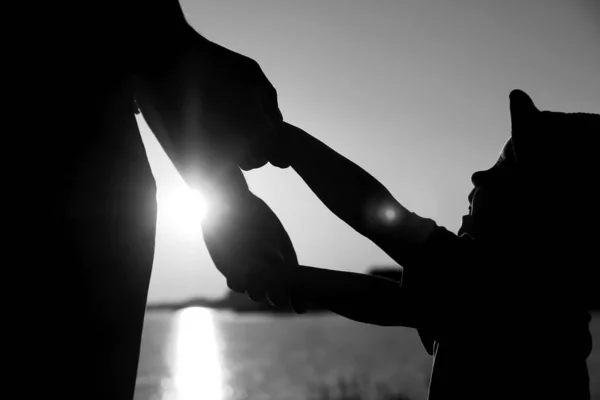 Silhouette the parent holds the hand of a child — Stock Photo, Image