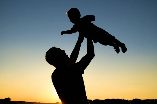 Silhouet van vader en zoon op zonsondergang — Stockfoto