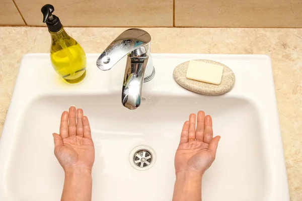 Ein Händewaschen mit Seife unter dem Wasserhahn mit Wasser — Stockfoto