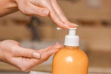 Musluğun altında sabun ve su ile yıkanan eller.