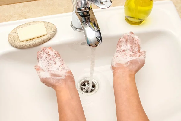 Ein Händewaschen mit Seife unter dem Wasserhahn mit Wasser — Stockfoto