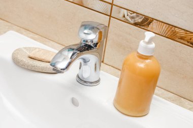 Musluğun altında sabun ve su ile yıkanan eller.