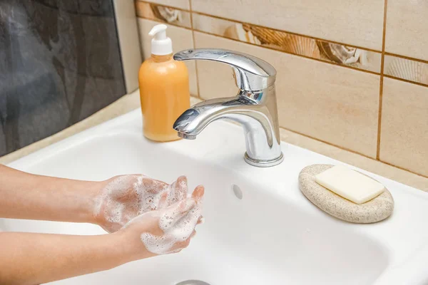 Ein Händewaschen mit Seife unter dem Wasserhahn mit Wasser — Stockfoto